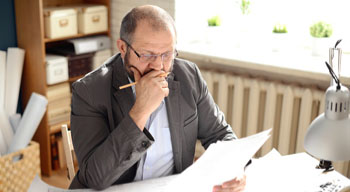 Mature adult man looking at paperwork in the office